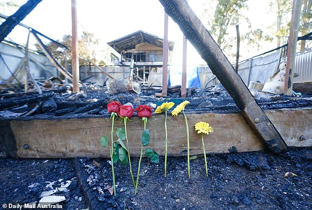 At the scene of the tragedy, roses and gerberas were left against a charred piece of masonry