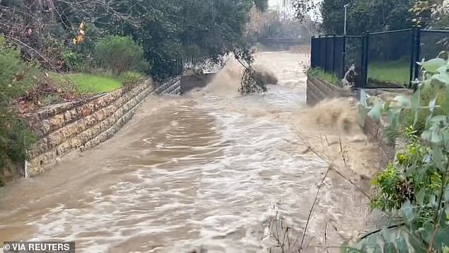 Significant damage is still possible as heavy rains are forecast to flood the Golden State on Wednesday.  Pictured: Floodwaters flowing in Montecitio