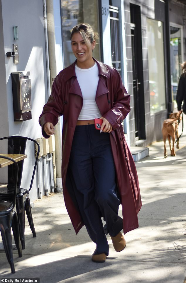 Sara looked chic in a maroon trench coat over a white top, tucked into high-waisted navy trousers