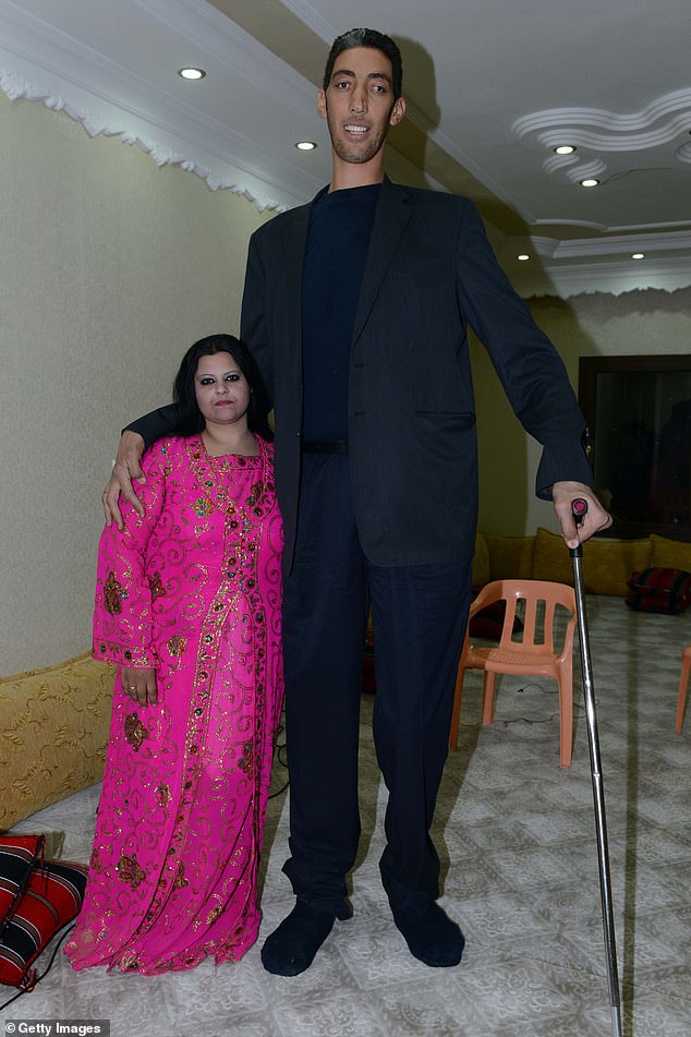 The world's tallest man Sultan Kosen (R) poses with his fiancée Merve Dibo during their henna evening, the ceremony held a day before the wedding, on October 26, 2013