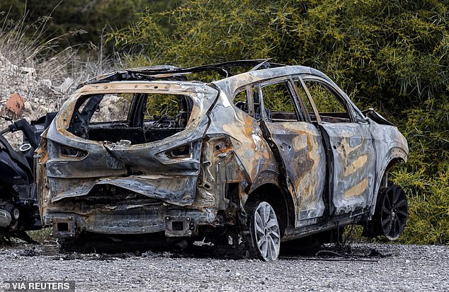 A burnt-out car allegedly used by the perpetrators of the murder of Russian pilot Maksim Kuzminov to escape is parked outside the Spanish Guardia Civil barracks, in El Campello, Spain