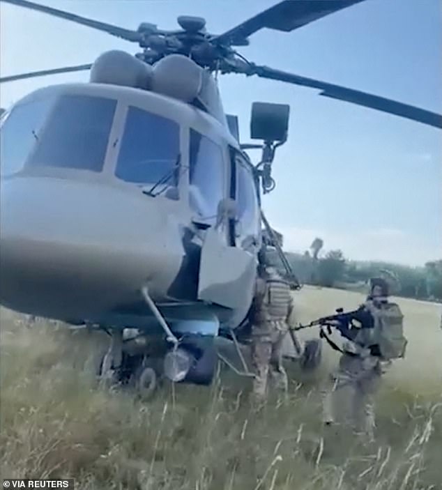 Pictured: Ukrainian intelligence officers inspect a Russian helicopter that they say was handed over to Ukraine by Russian pilot Maksim Kuzminov