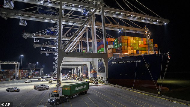 Five ship-to-shore cranes and gangs of dock workers work to load and unload the container ship at the Port of Savannah, Georgia