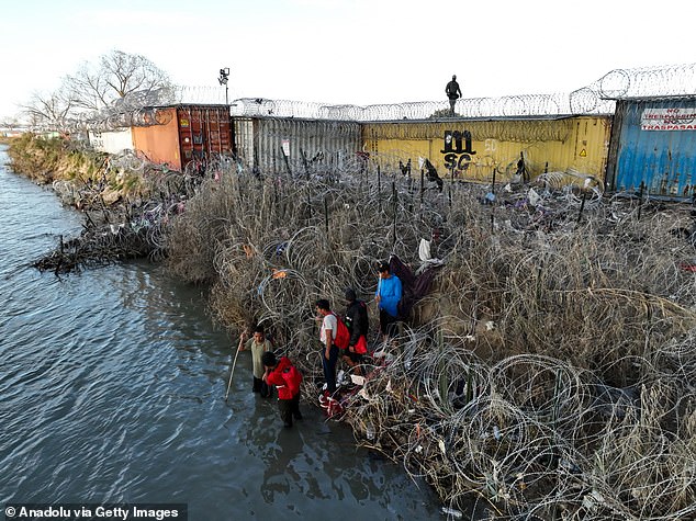 An aerial photo shows a group of immigrants trying to cross the Texas border despite increased security measures in Eagle Pass, Texas