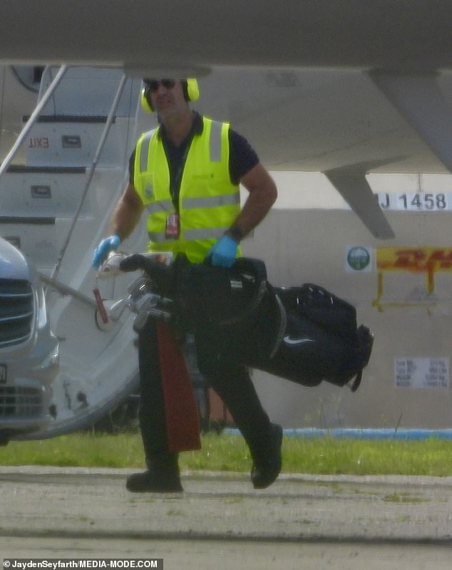 As he stepped off Taylor's private jet at Sydney Airport after landing at 8.57am, airport staff were seen carrying his Bombardier Global 6000 golf clubs.