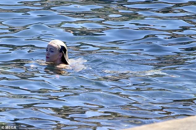 She seemed to be enjoying her solo time as she paddled around in the ocean