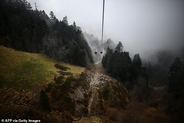 FRANCE: A gondola lift will be shown going over bare fields and trees at the Artouste ski resort in France on Monday.  Normally, skiers enjoy snowy slopes