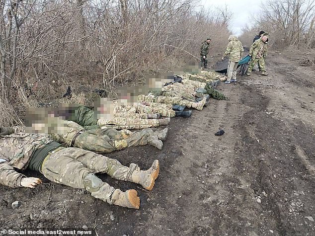 The dead soldiers line up as comrades prepare body bags