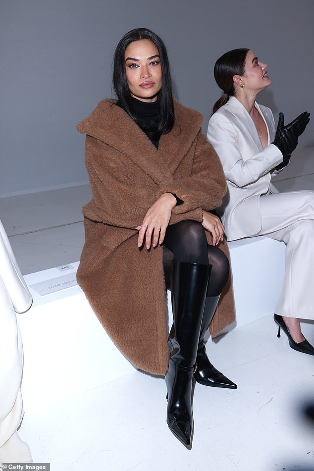 She topped a black ensemble with the shin-length coat, highlighted by a turtleneck top and a pair of $3,000 YSL knee-high boots.