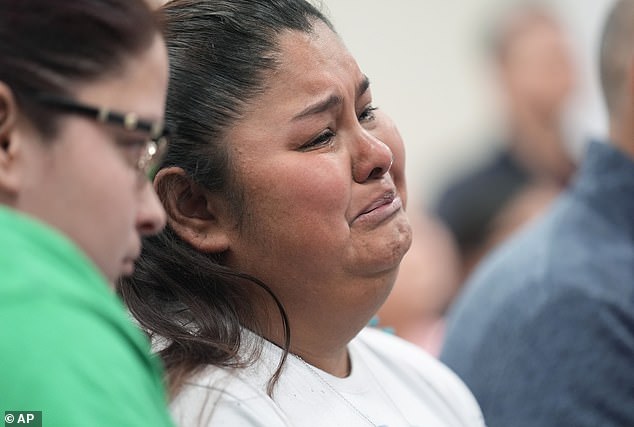 Evadulia Orta, left, and Felicia Martinez, right, and other family members of shooting victims hold back tears as they hear the damning report