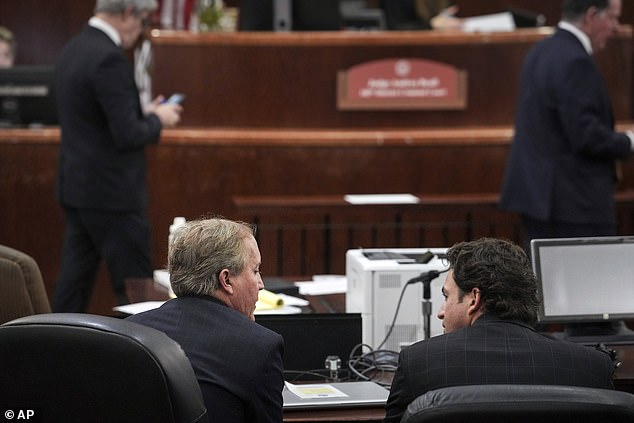 Texas Attorney General Ken Paxton, front left, talks with his attorney Anthony Osso, Jr., during a hearing in his securities fraud case, Friday, Feb. 16, at the Harris County Courthouse in Houston.  A judge on Friday rejected Paxton's efforts to dismiss the securities fraud charge that has shadowed the Republican for nearly a decade.