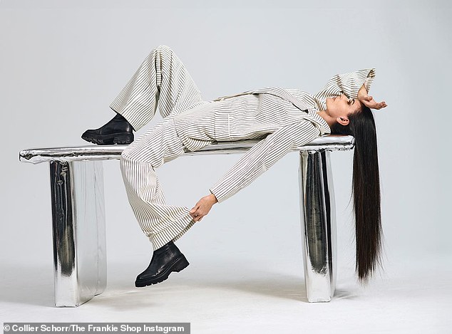 In another image from the campaign, Demi lay on a silver table with her hair hanging over the edge and almost touching the floor.  She wore a white suit with black pinstripes and black loafers with shoe soles