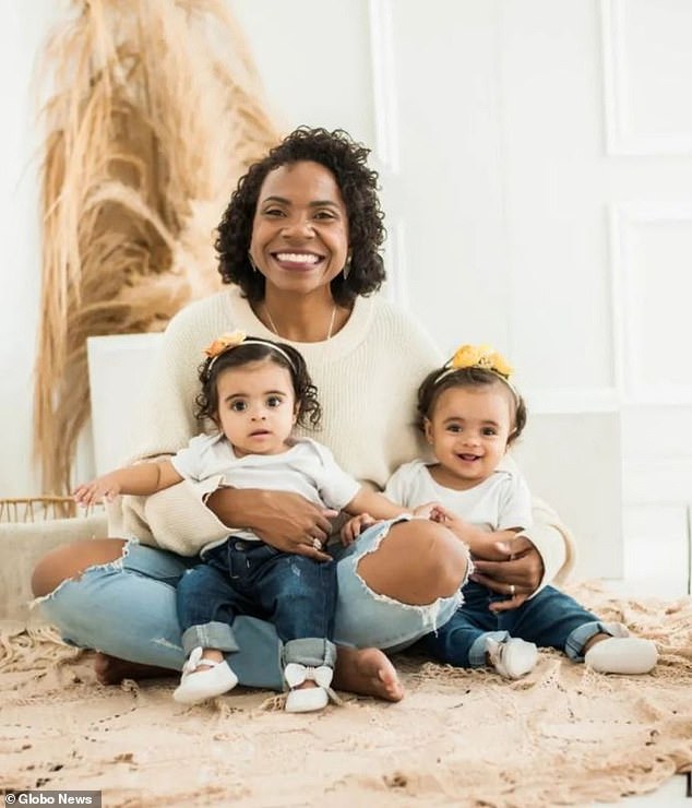 Berlandia Mendes and her one-year-old twin daughters were rescued by a bus passenger on Wednesday when she became trapped in the family vehicle as water rushed down a Rio de Janeiro street.