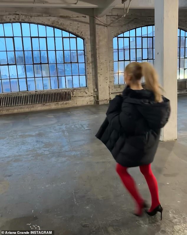 The Thank U, Next star was also seen running around an empty room, wearing red tights and a black puffer coat