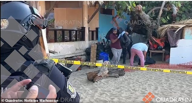 Mexican law enforcement officers remove body bags containing the bodies of two men found tortured to death in a cabana on an Acapulco beach on Thursday