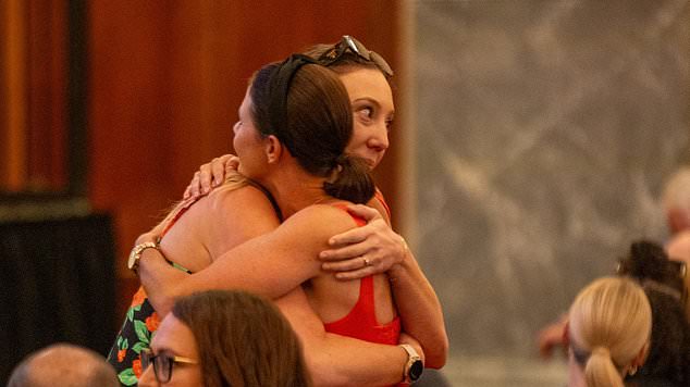 A tear fell down the face of her sister Jessica Locke (pictured hugging a mourner) as she reflected on how today was meant to be Melissa's first birthday spent at home after many years apart.