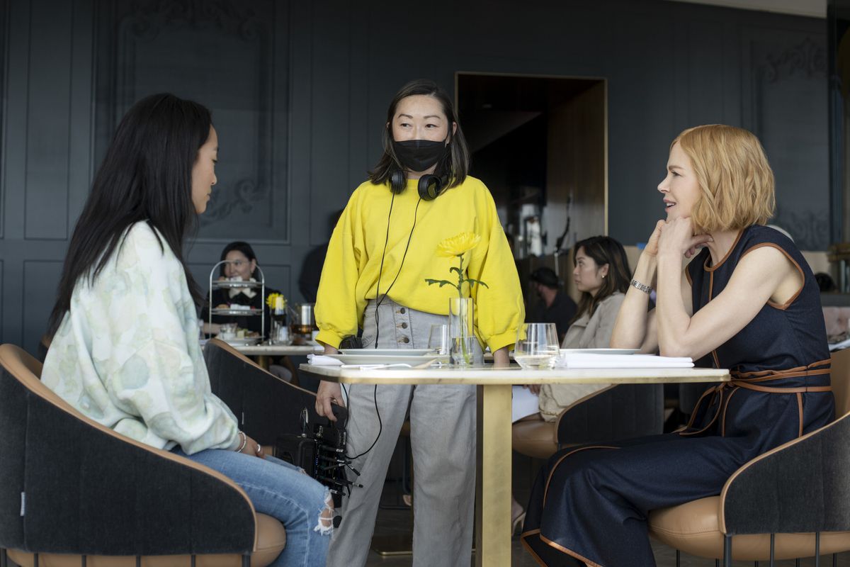 Lulu Wang stands at a table with Ji-young Yoo and Nicole Kidman backstage at Expats