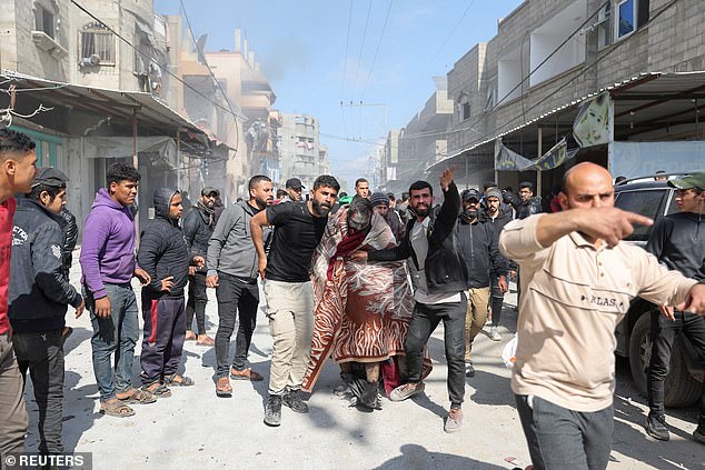 Palestinians help an injured man after the bombing in Rafah.  Four women and a child were reportedly killed