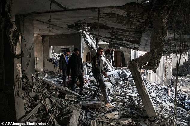 Palestinian artist Mahmoud Zuaiter inspects the ruins of his house after an airstrike on the house in Deir al-Balah in the central Gaza Strip on February 24