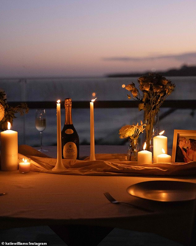 Looking back on the proposal, Katie revealed she set up a beautiful beachside proposal, complete with flowers and candles (pictured), keeping it all a Georgia surprise.