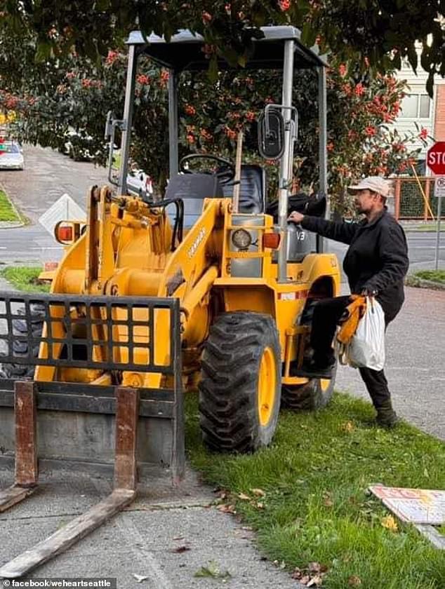 Irwin is seen carrying some bags as he climbs onto the excavator he stole