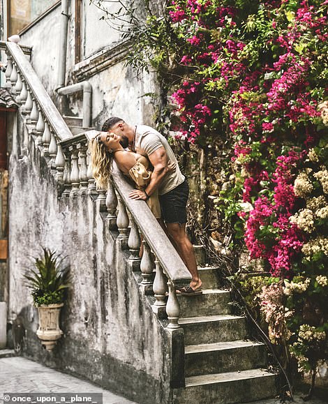 In Kuala Lumpur, Malaysia, the couple stopped to take a photo next to this striking flower wall