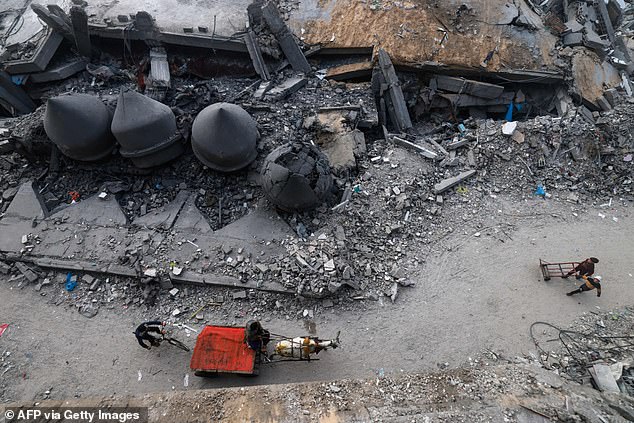 A donkey-drawn car passes the Al-Faruq Mosque, razed by Israeli bombing in Rafah