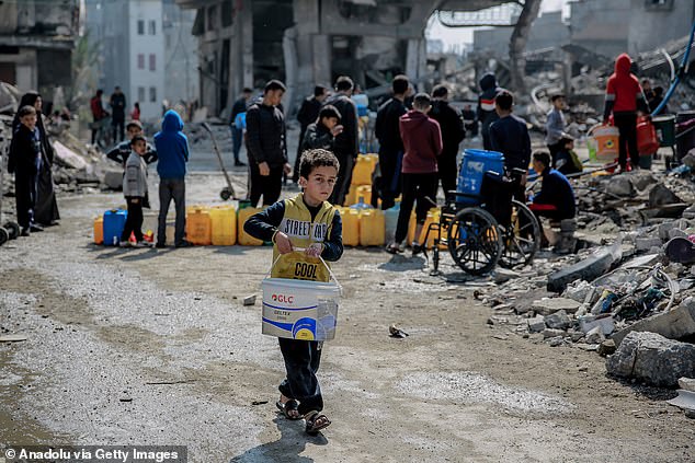 Palestinians wait with empty water jerry cans to refill them with clean water