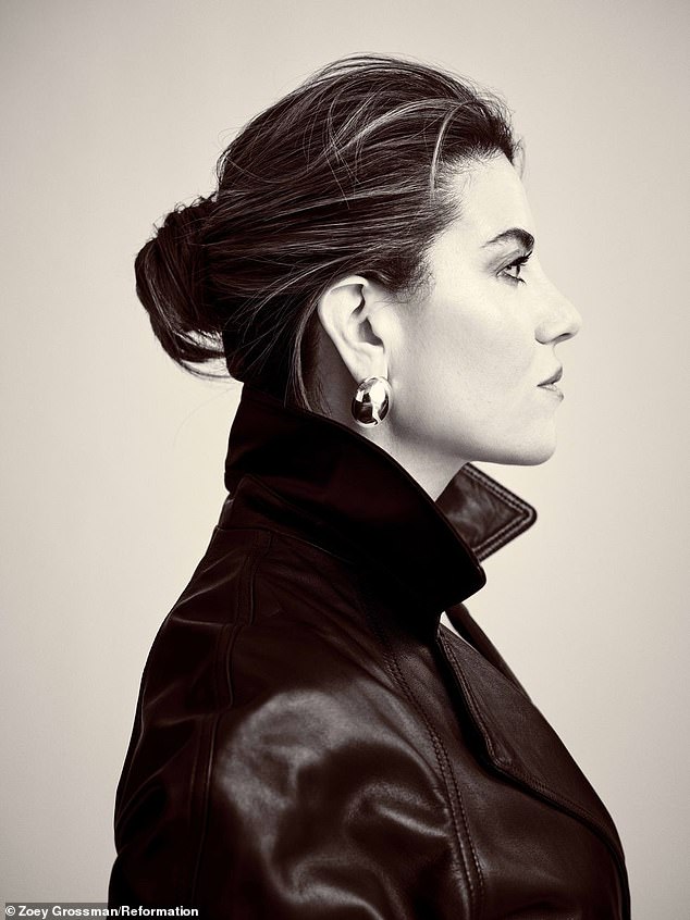 A profile view of Lewinsky wearing a chic black leather Veda Ashland trench