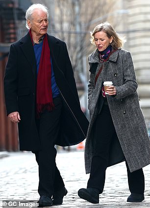 Bill wore a dark blue jacket over a light blue shirt and black trousers as he walked on the city sidewalk with Naomi, who also kept warm with a colorful scarf