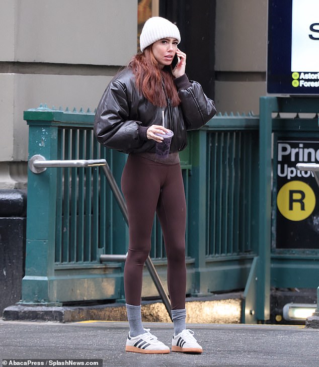 Petra put on brown leggings, combined with a trendy black leather jacket and white Adidas sneakers