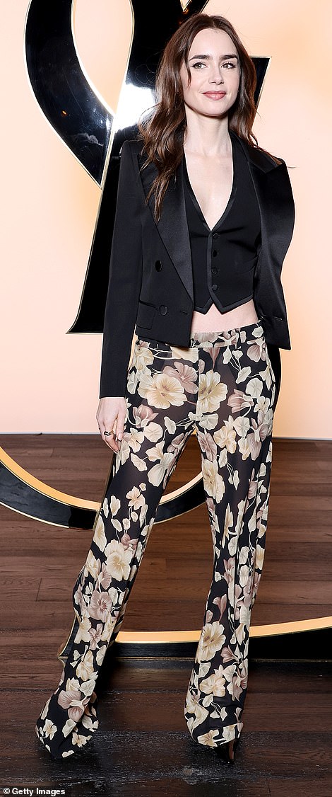She wore black flared trousers with a floral print in beige tones and wore a pair of black heels to add a few inches to her figure.