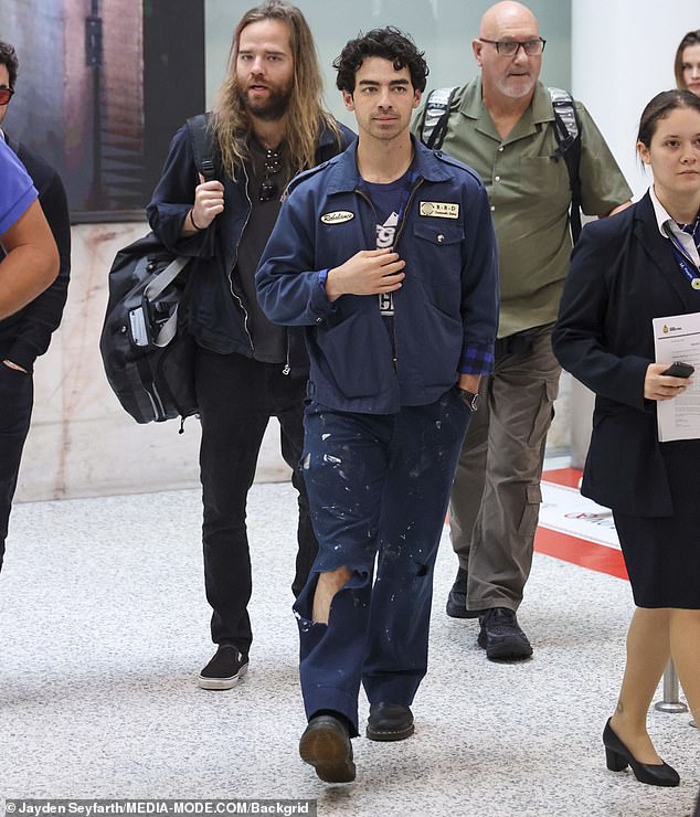 Joe, 34, looked stylish in a retro mechanic's uniform which consisted of ripped trousers and a matching jacket, teamed with a blue T-shirt