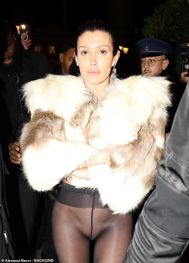 She appeared to be wearing no shirt or bra under a short fur coat as she returned to the Ritz Hotel with Kanye in a hoodie after enjoying dinner at Ferdi's.