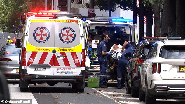 The injured man is seen being placed into an ambulance in Castlereagh Street