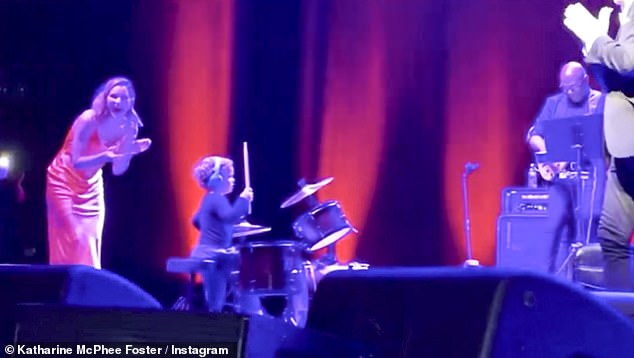 In the clip, the toddler can be seen playing the drums with headphones on as his famous dad plays the piano and Katharine watches from the edge of the stage.