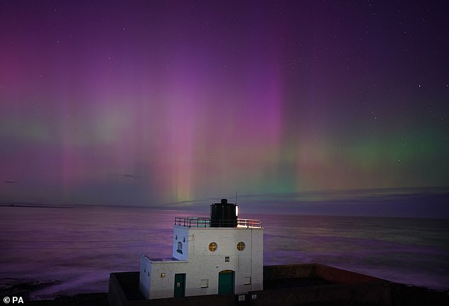 The aurora borealis appears over Bamburgh lighthouse, in Northumberland on the northeast coast of England, November 5, 2023