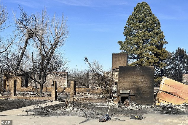 The remains of a burned-out home in Canada, Texas, smoldered Wednesday