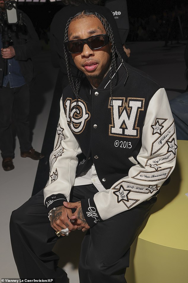 Tyga wore a similar baseball jacket to Serena as he took his seat in the front row