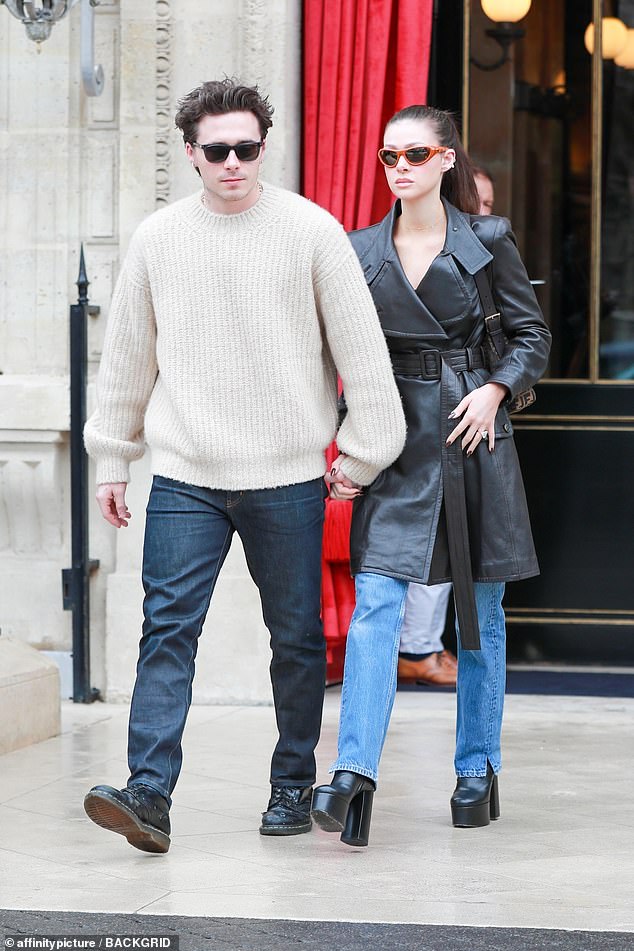 Nicola was holding hands with 24-year-old Brooklyn, who paired a knitted white sweater with Dr.  Martens boots