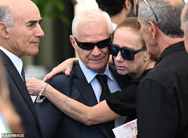 Victor White (pictured) was comforted by loved ones outside the church