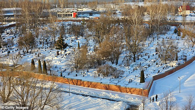 Russian police officers guard the area near the fence of the Borisov cemetery where Alexei Navalny is expected to be buried this week, on February 27, in Moscow.