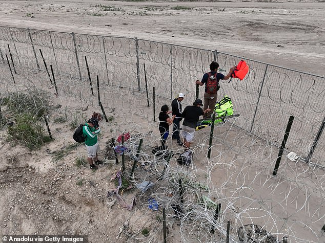 Migrants cross the border at Eagle Pass, Mexico.  Both Biden and Trump head to the southern border for dueling events on Thursday as polls show immigration is a major issue among swing state voters.
