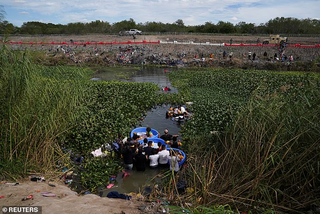 People cross the Rio Grande River to present themselves to authorities in Brownsville, Texas, to begin their immigration process