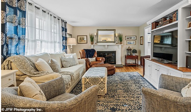 The living room features a wood-burning stove and a wall of windows that let in plenty of natural light