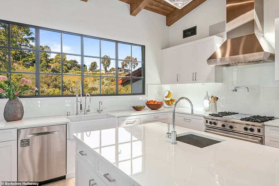 The kitchen is bright white and modern