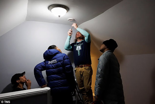 Chris Amatore fixes a smoke detector in one of fifteen buildings around Chicago that he has converted into housing for 500 migrants