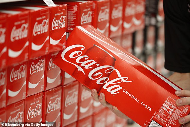 Coca-Cola reported that overall sales rose despite price increases of about 10 percent last year.  The photo shows an employee stocking shelves at a store in Orem, Utah