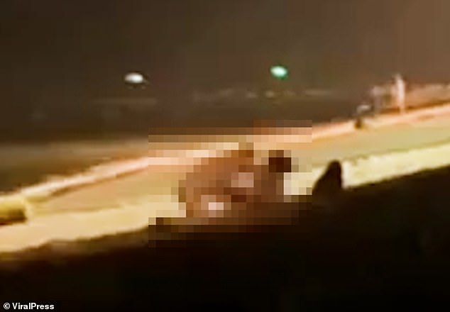 Despite there being people around and bright street lights, a couple, believed to be tourists, engaged in sexual activity on a beach in Thailand.  People looked at it and laughed