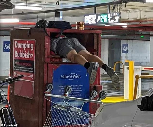 The man climbed into the charity box with a cart and looked for what he could take with him